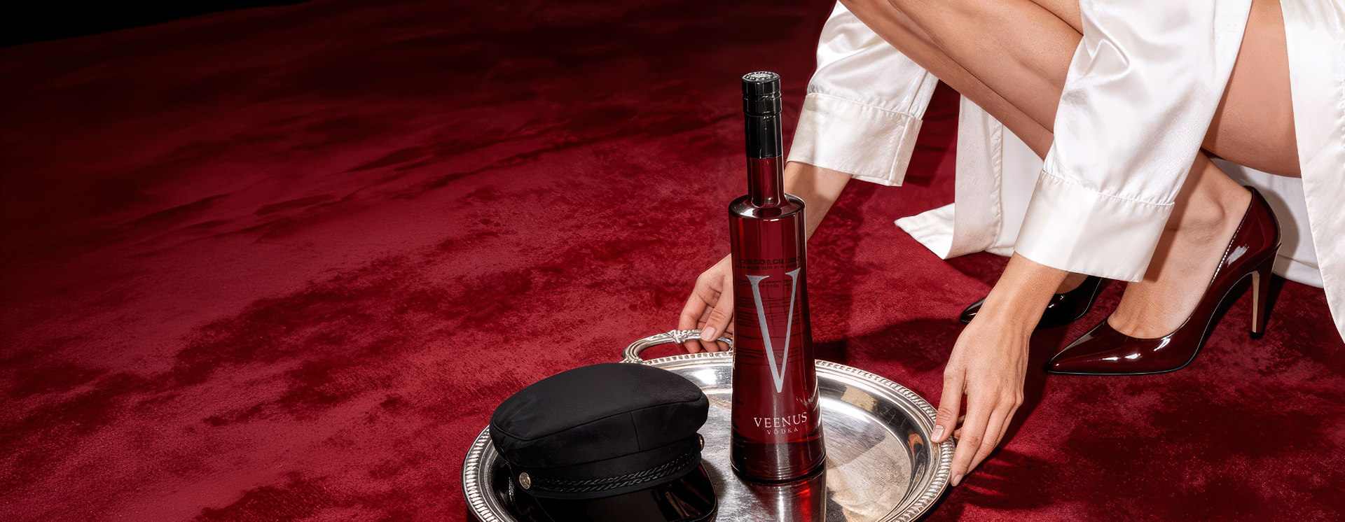 Veenus Vodka bottle on a silver tray over deep red velvet
